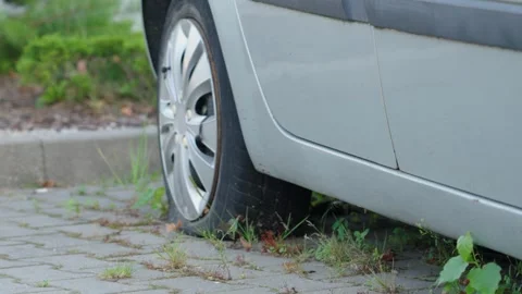 Flat tire in a quiet parking area on a sunny day Stock Footage 329615175