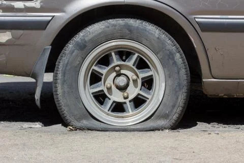 Flat tyre in sunshine Stock Photos