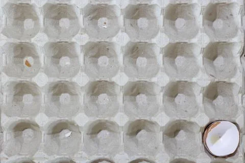 Flat view of a box with broken eggshell brown chicken eggs, background textur Stock Photos