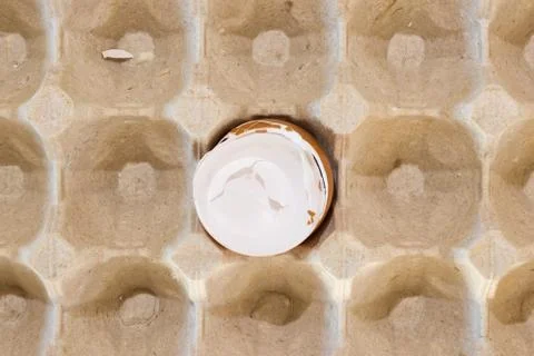 Flat view of a box with broken eggshell brown chicken eggs, background texture Stock Photos