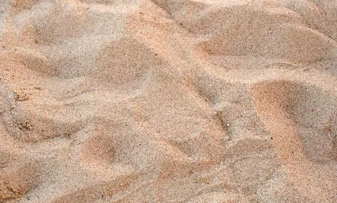 Flat view of clean yellow sand surface covering seaside beach. Sandy texture Foto stock