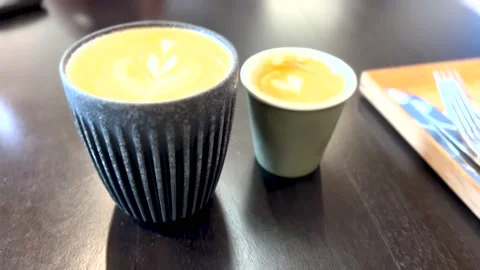 Flat white and piccolo coffee, two clay cups of coffee sitting on a table in a Stock Footage 166884555