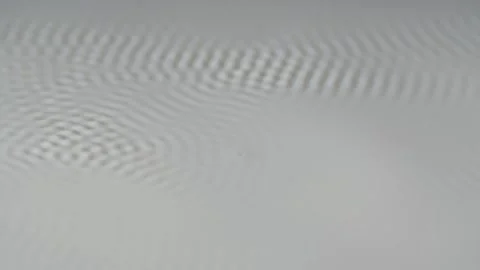 Flat white surface of milk begins to vibrate to frequency of speaker. Macro shot 動画素材 155286619