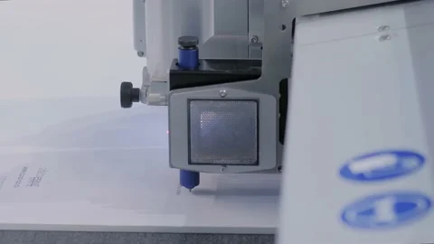 Flatbed cutter with drawing pen module writing text on white paper sheet Stock Footage 150800314