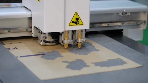 Flatbed cutter, plotter cutting cardboard sheet at printer exhibition: close up Stock Footage 152341696