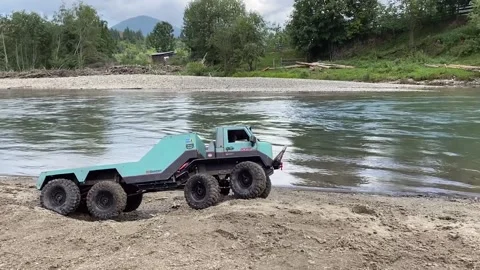Flatbed towing truck going on river shore sand. Stock Footage 207401373