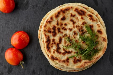 Flatbread with cheese and herbs on a dark plate Foto stock