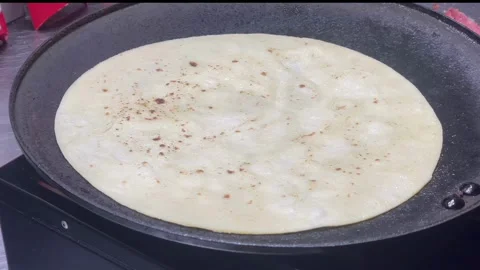 Flatbread or kebab skin being cooked on a hot griddle pan. Видео 334324962