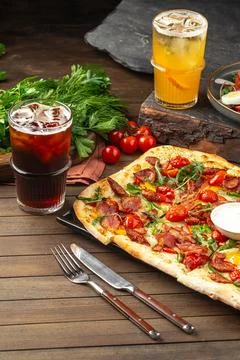 Flatbread pizza served with sauces and drinks Stock Photos