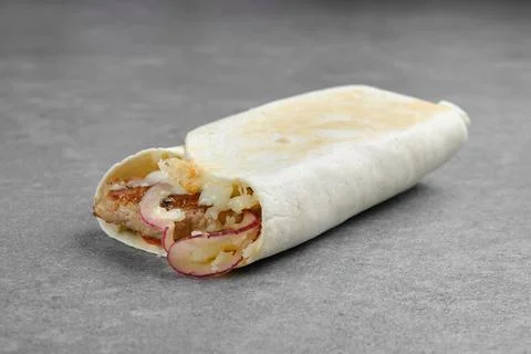 Flatbread rolled with with beef patty, pickled onion, cabbage and melted chee Stock Photos