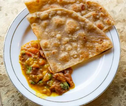 Flatbread Served with Curry on a White Plate at a Hotel Breakfast Stock Photos