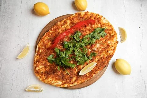 Flatbread with spices and herbs served on a wooden board with lemons Stock Photos
