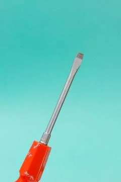 Flathead Screwdriver Over a Turquoise Background Stock Photos