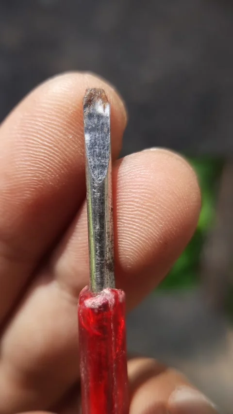 Flathead screwdriver tip, close-up metal tool blade held by hand, vertical sh Vídeo Stock 342627567