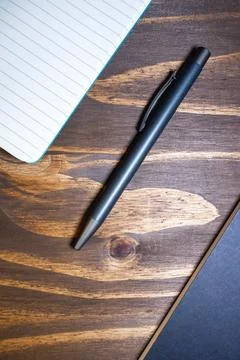 Flatlay background of a pen and a notebook, on a wooden background Stock Photos