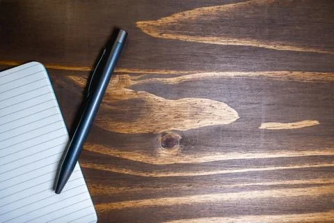 Flatlay background of a pen and a notebook, on a wooden background Stock Photos