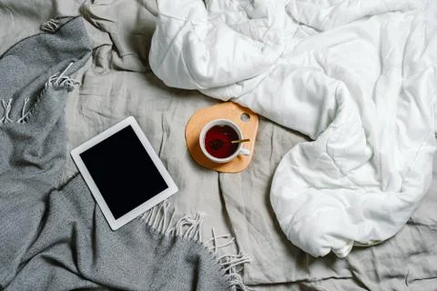Flatlay of a bed with tablet and tea, selective focus Stock Photos