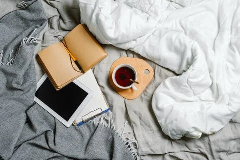 Flatlay of a bed with tablet and tea, selective focus Stock Photos