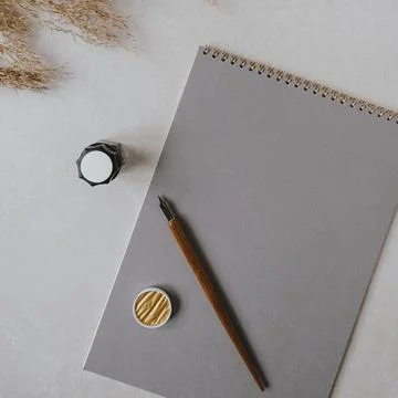 Flatlay blank paper sheet pad, pampas grass, fountain pen, golden ink on beig Stock Photos