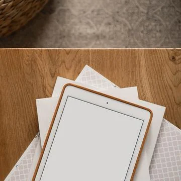 Flatlay of blank screen tablet pad, paper sheets on wooden table and carpet.  Stock Photos