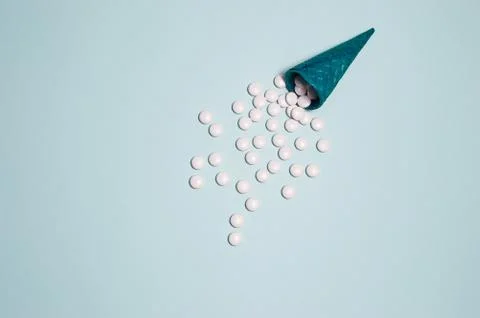 Flatlay of blue crispy waffle cone with white pills instead of ice cream on a Stock Photos