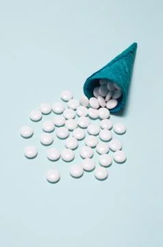 Flatlay of blue crispy waffle cone with white pills instead of ice cream on a Stock Photos