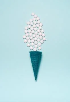 Flatlay of blue crispy waffle cone with white pills instead of ice cream on a Stock Photos