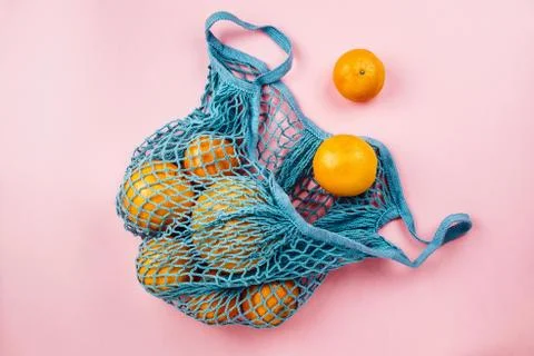Flatlay of blue linen eco bag with oranges inside, zero waste groceries conce Stock Photos