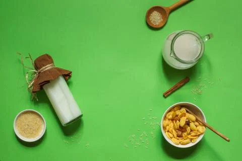 Flatlay on a bright green background with a bottle of rice milk, corn flakes Stock Photos