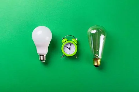 Flatlay Clock with light bulb, calculator on a green background. Minimalism.. Foto stock