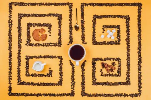 Flatlay of coffee cup in the middle of pattern or labyrinth made of coffee be Stock Photos