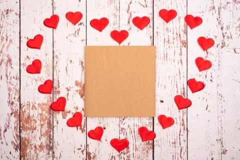 Flatlay composition with hearts and a sheet of paper on a wooden background Stock-Fotos