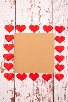 Flatlay composition with hearts and a sheet of paper on a wooden background Stock Photos