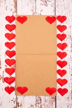 Flatlay composition with hearts and a sheet of paper on a wooden background Stock Photos
