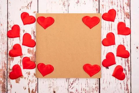 Flatlay composition with hearts and a sheet of paper on a wooden background Stock-Fotos