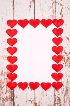 Flatlay composition with hearts and a sheet of paper on a wooden background Stock Photos