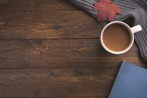 Flatlay composition with knitted scarf, cup of coffe, book, and yellow leaves Stock Photos