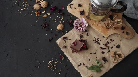 Flatlay on dark background with chocolate, walnut, wood board and paper Video stock 90524893