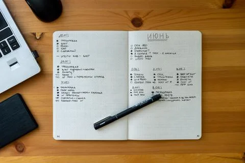 Flatlay of a diary, notebook and a pen on a wooden table Stock Photos