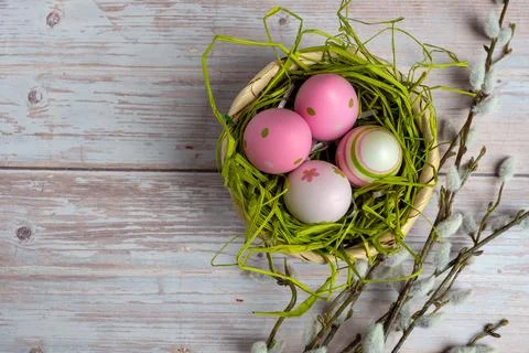 Flatlay Of Easter Eggs In Pink Surrounding Nest On Rustic Wooden Planks Stock Photos