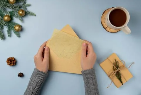 Flatlay envelop in woman's hands with blank of Christmas greeting card Stock Photos