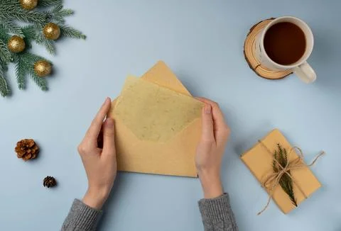 Flatlay envelop in woman's hands with blank of Christmas greeting card Stock Photos