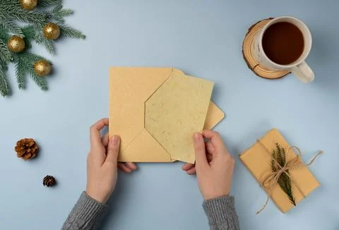 Flatlay envelop in woman's hands with blank of Christmas greeting card Stock Photos