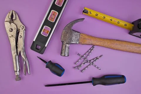Flatlay of Hand Tools Pruple Background Including Hammer, Nails, Tape Measure Stock Photos