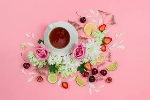 Flatlay of hot cup of tea with various berries and flowers Stock Photos
