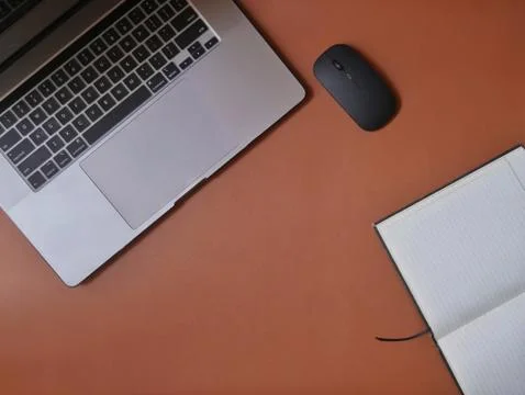 Flatlay: laptop, mouse, notebook on a brown leather desk Stock Photos