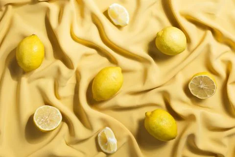 Flatlay of lemons lying on yellow fabric Stock Photos