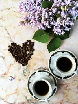 Flatlay with lilac two cups and coffee beans Stock Photos