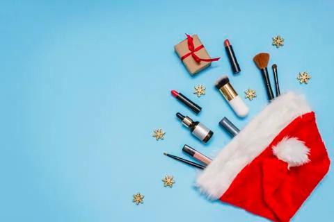 Flatlay with makeup products and Christmas decor on a blue background. make-u Stock Photos