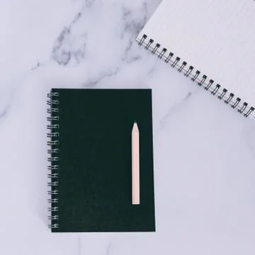 Flatlay of mini spiral notebooks on marble desk Stock Photos